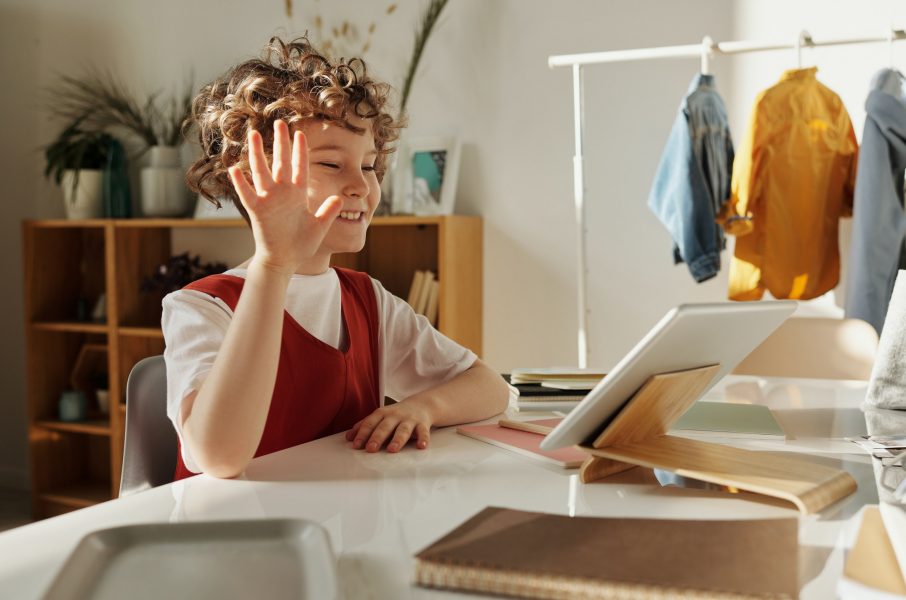little girl with hands up in front of computer